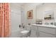 Bright bathroom featuring a tub with shower, white vanity, and decorative pink floral shower curtain at 4459 Bluff Oak Loop, Kissimmee, FL 34746