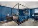 A modern bedroom features a canopy bed, blue accent wall, and a dedicated workspace at 4459 Bluff Oak Loop, Kissimmee, FL 34746