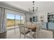 Bright dining room with a modern chandelier, stylish furnishings, and sliding glass doors to the outdoors at 4459 Bluff Oak Loop, Kissimmee, FL 34746