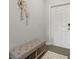 Cozy entryway with a neutral-toned bench, decorative wall hangings, and a light-colored door at 4459 Bluff Oak Loop, Kissimmee, FL 34746
