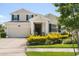 Charming two-story home featuring well-manicured landscaping, a front porch, and an attached garage at 4459 Bluff Oak Loop, Kissimmee, FL 34746