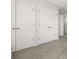 Hallway with multiple white doors, neutral carpeting, and access to various rooms at 4459 Bluff Oak Loop, Kissimmee, FL 34746