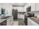 Modern kitchen with stainless steel appliances, gray countertops, and ample cabinet space at 4459 Bluff Oak Loop, Kissimmee, FL 34746