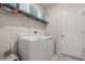Well-lit laundry room featuring a white washer and dryer set with storage shelves above at 4459 Bluff Oak Loop, Kissimmee, FL 34746