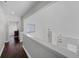 Upstairs hallway featuring hardwood floors and view of the foyer with pendant lighting at 479 Cidermill Place, Lake Mary, FL 32746