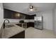 Contemporary kitchen featuring granite countertops, dark wood cabinets, and stainless steel appliances at 479 Cidermill Place, Lake Mary, FL 32746
