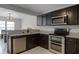 Contemporary kitchen featuring granite countertops, dark wood cabinets, and stainless steel appliances at 479 Cidermill Place, Lake Mary, FL 32746