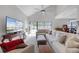 Bright living room boasts high ceilings, neutral decor, a ceiling fan, and sliding glass doors to the pool at 479 Cidermill Place, Lake Mary, FL 32746