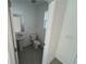 Cozy half-bathroom featuring modern fixtures, a pedestal sink, and a window for natural light at 4891 Lyric Dr, Mascotte, FL 34753