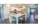 Open kitchen featuring a large island with seating, white cabinetry and stainless steel appliances at 4891 Lyric Dr, Mascotte, FL 34753
