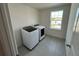 Functional laundry room with modern appliances and natural light from the window at 4891 Lyric Dr, Mascotte, FL 34753