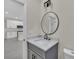 Stylish bathroom with grey vanity, round mirror, and modern black faucet, complemented by tile flooring at 714 Palmetto Ave, Orange City, FL 32763