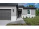 Close-up of the front exterior showing a dark front door flanked by plants and modern outdoor wall lamps at 714 Palmetto Ave, Orange City, FL 32763
