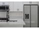 Close-up of a modern kitchen featuring white cabinets, stainless steel appliances, and a stylish island with sink at 714 Palmetto Ave, Orange City, FL 32763