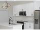Well-lit kitchen features white cabinets, stainless steel appliances, granite countertops, and an island with a sink at 714 Palmetto Ave, Orange City, FL 32763
