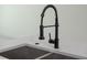 Close up on a modern black gooseneck kitchen faucet and stainless steel sink set in bright countertop at 714 Palmetto Ave, Orange City, FL 32763