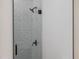 Stylish shower with matte black fixtures, grey textured tile, and glass door at 714 Palmetto Ave, Orange City, FL 32763