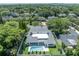 An aerial perspective of a stunning home with a refreshing pool, manicured lawn, and lush greenery at 731 Williams Dr, Winter Park, FL 32789