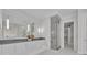 Bright bathroom featuring dual sinks, a large mirror, and a frameless glass shower at 731 Williams Dr, Winter Park, FL 32789