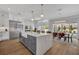 A large kitchen island with an apron sink, stainless steel appliances, and views of the dining room and backyard pool at 731 Williams Dr, Winter Park, FL 32789