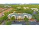 An aerial view of an apartment complex with a green roof and ample parking nestled in a lush, green landscape at 8908 Legacy Ct # 303, Kissimmee, FL 34747