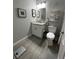 Well-lit bathroom featuring a modern vanity, toilet, and decorative shelves at 8908 Legacy Ct # 303, Kissimmee, FL 34747