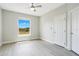 Bright bedroom with a ceiling fan, a large window with a view, and light gray flooring at 8908 Legacy Ct # 303, Kissimmee, FL 34747
