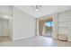 A minimalist bedroom with gray wood floors, neutral walls, ceiling fan, and a sliding glass door to a private balcony at 8908 Legacy Ct # 303, Kissimmee, FL 34747