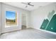 A well-lit bedroom featuring light gray flooring, mountain wall art, and a view of nature at 8908 Legacy Ct # 303, Kissimmee, FL 34747