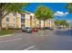 A well-maintained apartment complex with tan and white facade with ample parking and lush landscaping at 8908 Legacy Ct # 303, Kissimmee, FL 34747