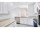 A bright, updated kitchen features granite countertops, stainless steel appliances, white cabinets, and a stylish faucet at 8908 Legacy Ct # 303, Kissimmee, FL 34747
