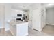 An open kitchen with granite countertops, white cabinets, stainless steel appliances, and light gray wood flooring at 8908 Legacy Ct # 303, Kissimmee, FL 34747
