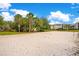 A sunny sand volleyball court is ready for a match with palm trees nearby, and a view of the apartments at 8908 Legacy Ct # 303, Kissimmee, FL 34747