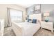 Serene bedroom featuring a plush white bed, soft blue accents, and ample natural light at 8993 Cabot Cliffs Dr, Davenport, FL 33896