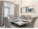 Elegant dining room with a marble table, seating for six, and a modern chandelier at 8993 Cabot Cliffs Dr, Davenport, FL 33896