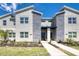 Modern townhouse with stone accents, manicured landscaping, and a welcoming entrance under a bright blue sky at 8993 Cabot Cliffs Dr, Davenport, FL 33896
