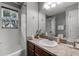 Bright bathroom featuring a shower-tub combination and a well-lit vanity area with neutral countertop at 913 Bending Oak Trl, Winter Garden, FL 34787