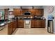 A well-equipped kitchen featuring dark cabinets, stainless steel appliances, and stylish backsplash at 913 Bending Oak Trl, Winter Garden, FL 34787