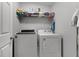 Functional laundry room featuring modern washer and dryer with shelf storage above at 913 Bending Oak Trl, Winter Garden, FL 34787