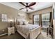 A cozy main bedroom with a comfortable bed, a ceiling fan, and two windows for natural light at 913 Bending Oak Trl, Winter Garden, FL 34787