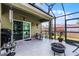 Screened in back patio with a table, grill, and view of the backyard at 913 Bending Oak Trl, Winter Garden, FL 34787