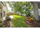 Landscaped backyard offers green grass, tropical foliage, and a peaceful setting at 9545 Southern Garden Cir, Altamonte Springs, FL 32714