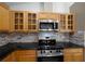 Modern kitchen featuring stainless steel appliances, granite counters, and wooden cabinetry at 9545 Southern Garden Cir, Altamonte Springs, FL 32714