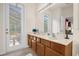 Bathroom with double vanity sinks, a large mirror, and a view to the pool area at 1031 Marcello Blvd, Kissimmee, FL 34746