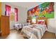 Bedroom featuring two twin beds, cartoon themed bedding, and large cartoon wall graphic at 1031 Marcello Blvd, Kissimmee, FL 34746