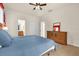 Comfortable bedroom with a ceiling fan, closet, and wooden dresser at 1031 Marcello Blvd, Kissimmee, FL 34746
