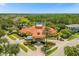 Aerial view of a community clubhouse with manicured landscaping, fountain, and community lake in the background at 1031 Marcello Blvd, Kissimmee, FL 34746