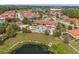 Aerial view of a community pool area with lounge chairs, shade coverings, and lush landscaping around a pond at 1031 Marcello Blvd, Kissimmee, FL 34746