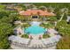 Aerial view of a community pool and clubhouse with tropical landscaping and comfortable seating at 1031 Marcello Blvd, Kissimmee, FL 34746