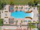 Aerial view highlighting a modern community pool surrounded by ample lounge seating, cabanas and lush tropical landscaping at 1031 Marcello Blvd, Kissimmee, FL 34746